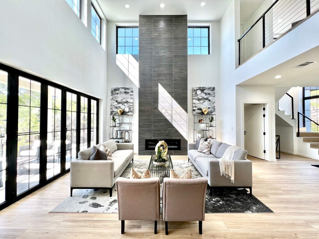 Luxury AAC concrete home interior with double-height living room, floor-to-ceiling fireplace, and modern furnishings